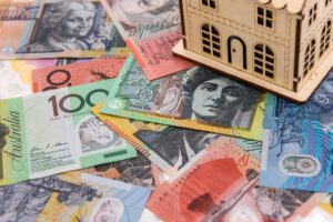 Calculator with wooden house model at australian dollars